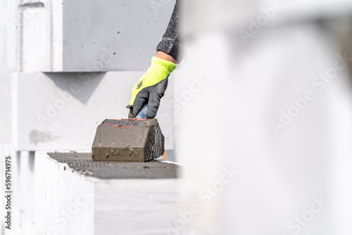 application of cement glue on concrete blocks. construction of a wall of concrete bricks