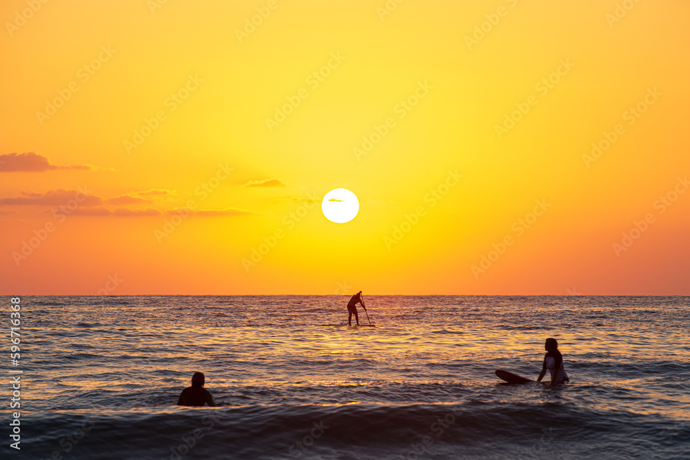 silhouette of a person on a sup at sunset