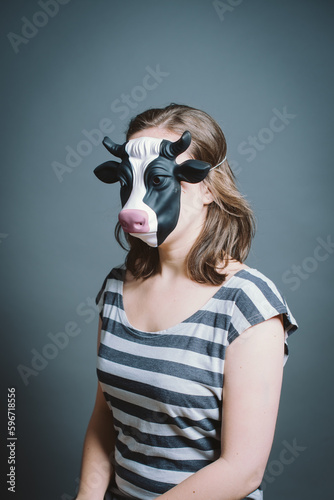 Young woman wearing mask against a grey background in studio. Young woman wearing mask against a grey background in studio. © Bevan G/peopleimages.com