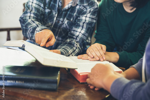 Small group of asian people praying worship believe. Teams of friends worship together before studying Holy bible. family praying together in church. Small group learning with prayer concept.