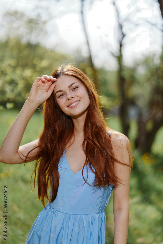 Woman smile with teeth in the spring on a sunny day happily walking in nature against the green grass, the concept of women's body health Woman smile with teeth in the spring on a sunny day happily walking in nature against the green grass, the concept of women's body health