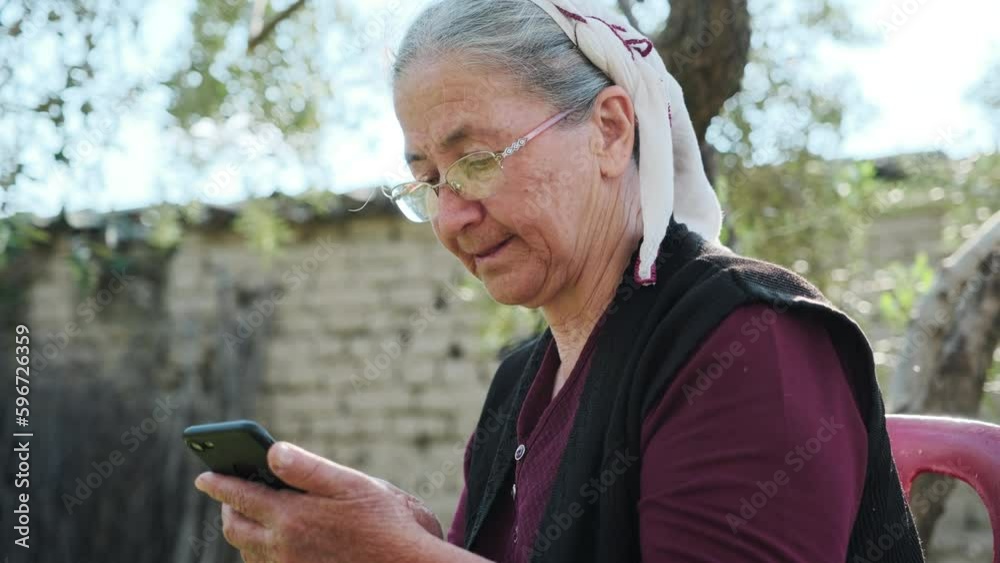 An elderly woman is experiencing technology. She is having a good time with her mobile phone in hand.
