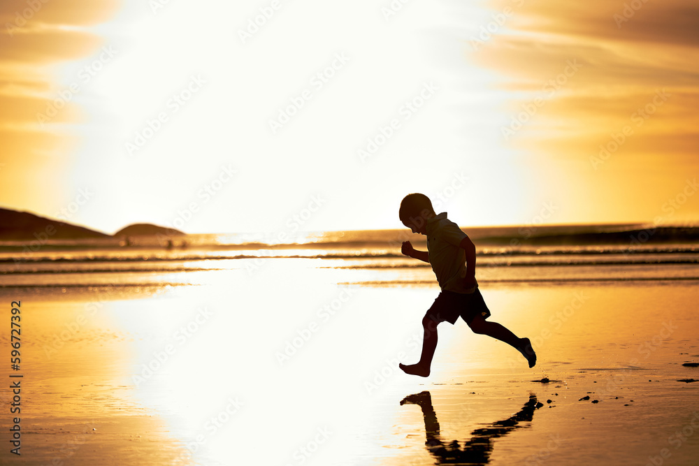 The pilot of a shooting star. Shot of an unrecognizable little boy running along the beach at sunset.