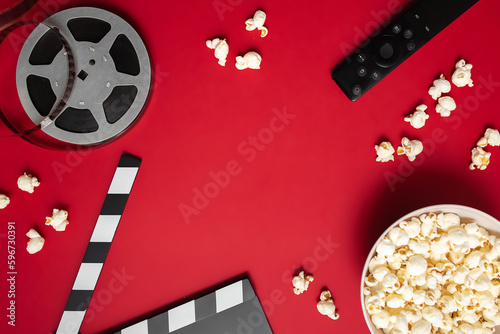 Canvas-taulu flat lay composition with popcorn, movie clapperboard, film reel and tv remote control on red background