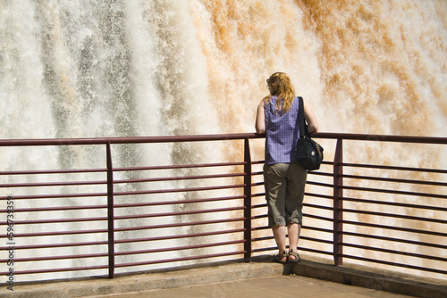Frau am Geländer schaut auf Floriano Wasserfall,Iguazu Nationalpark,Brasilien photo