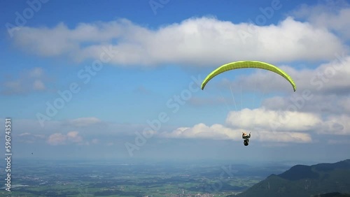Paraglider flies from Mount on an paraglider over beautiful landscape with lakes photo
