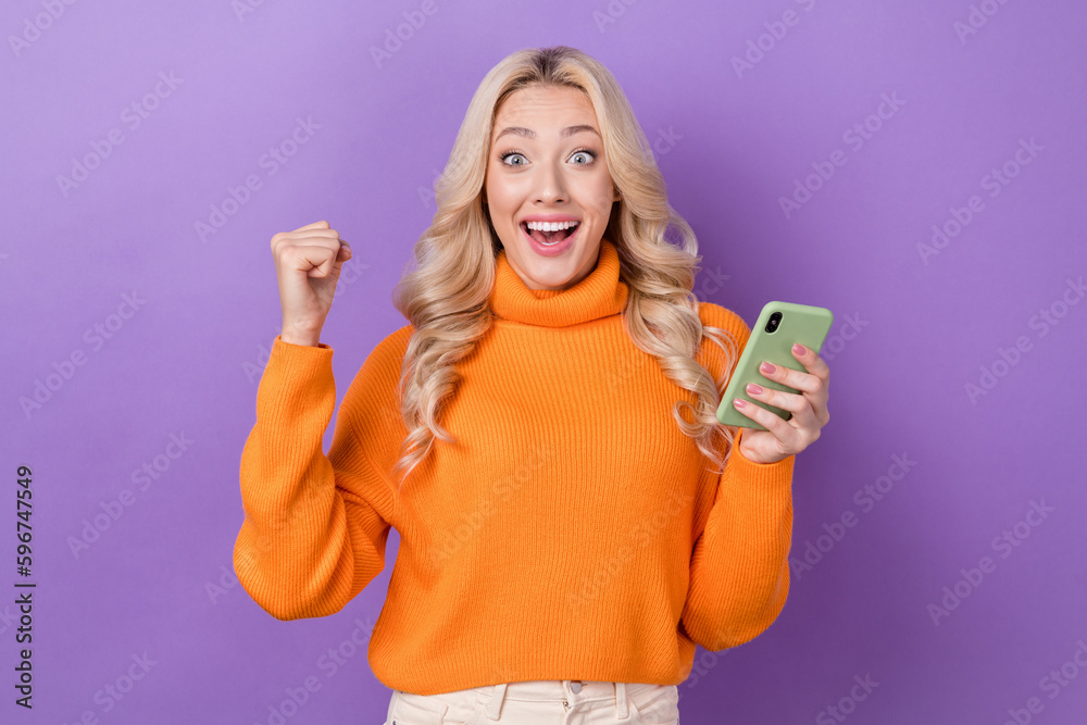 Portrait of ecstatic impressed woman elegant hairstyle wear pullover hold smartphone win betting isolated on violet color background Portrait of ecstatic impressed woman elegant hairstyle wear pullover hold smartphone win betting isolated on violet color background