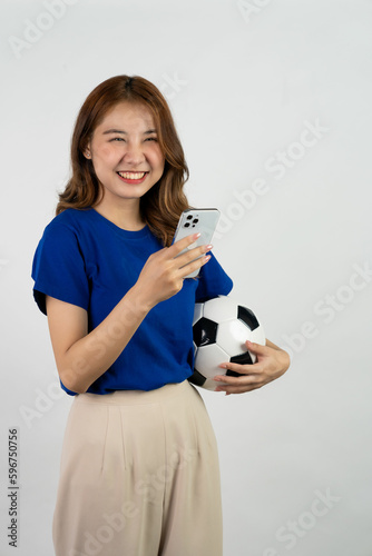 Pretty Asian female soccer fans celebrating on isolated white background female sports fan Asian girl in blue t-shirt holding soccer ball posing on white background