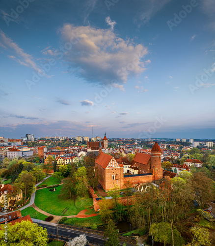 Olsztyn - park outside the castle, Łyna River, old town, castle, Evangelical church, high gate and co-cathedral basilica from a bird's eye view. spring light after sunset.
