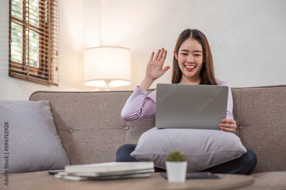 beautiful asian young woman wear casual sit on couch using computer laptop entertain with social media relax smile and laughing.Freelance woman working online sale marketing. Shopping online at home beautiful asian young woman wear casual sit on couch using computer laptop entertain with social media relax smile and laughing.Freelance woman working online sale marketing. Shopping online at home