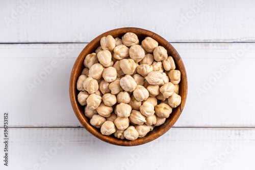 Chick pea uncooked beens. Studio shoot isolated on light wooden background. Up view shoot.