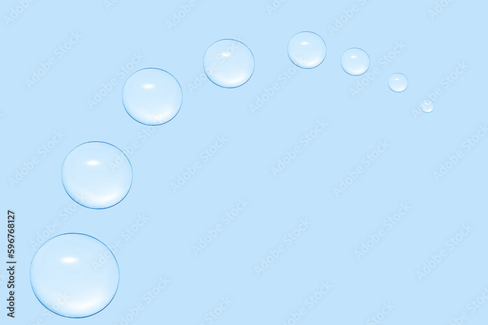 Drops of transparent gel or water in the shape of a semi-circle, with decreasing size. On a blue background.
