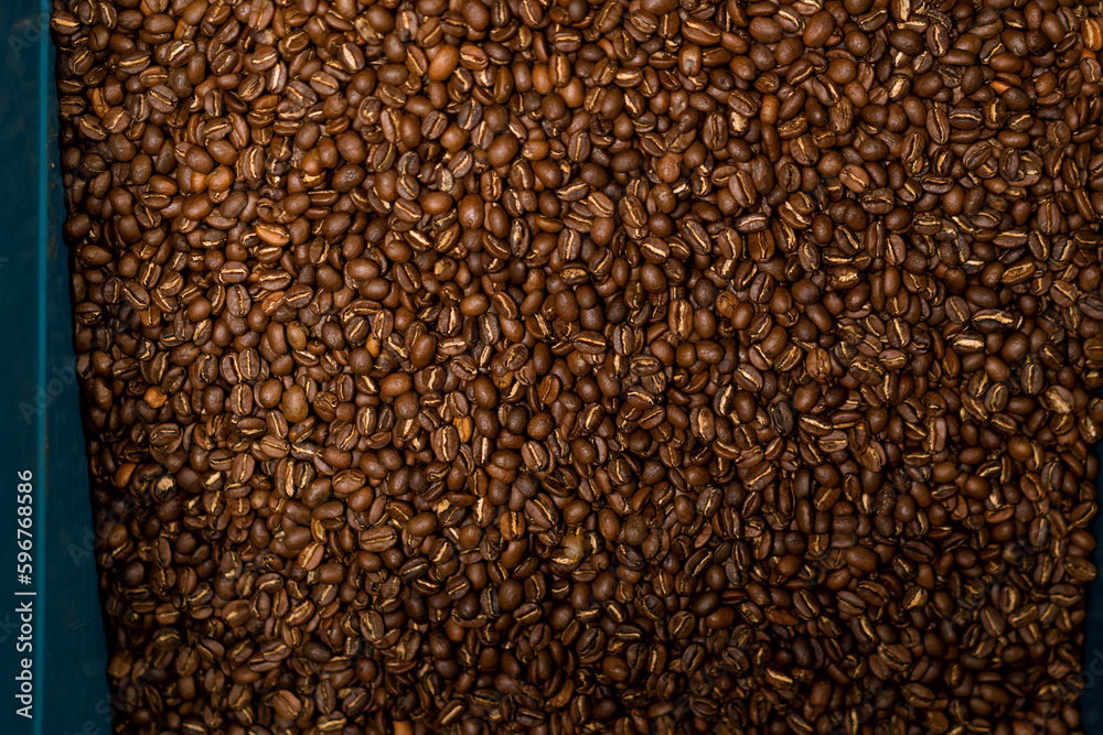 coffee production roasted and fragrant coffee beans lie in a box preparing for transportation close-up