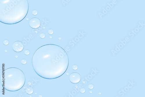 Drops of transparent gel or water in different sizes. On a blue background.