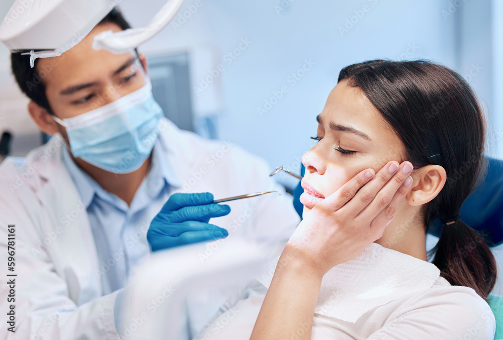 He wants to ensure a pain free experience. Shot of a young woman looking scared in the dentists chair. He wants to ensure a pain free experience. Shot of a young woman looking scared in the dentists chair.