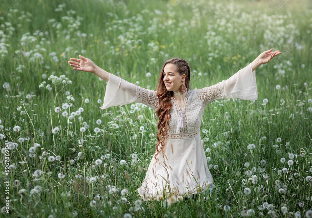 A beautiful young woman in the green grass and dandelions. Enjoy nature. A woman in a dress on a spring lawn. Freedom without allergies A beautiful young woman in the green grass and dandelions. Enjoy nature. A woman in a dress on a spring lawn. Freedom without allergies