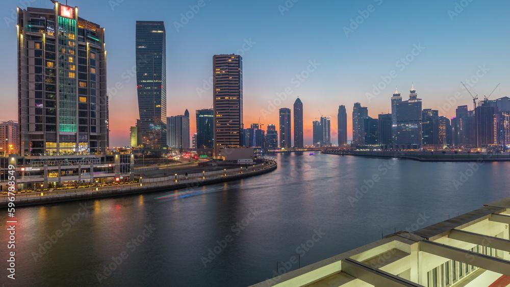 Naklejka premium Modern city architecture in Business bay district. Panoramic view of Dubai's skyscrapers day to night timelapse