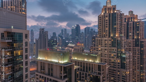 Dubai skyscrapers with golden sky over business bay district day to night timelapse. © neiezhmakov