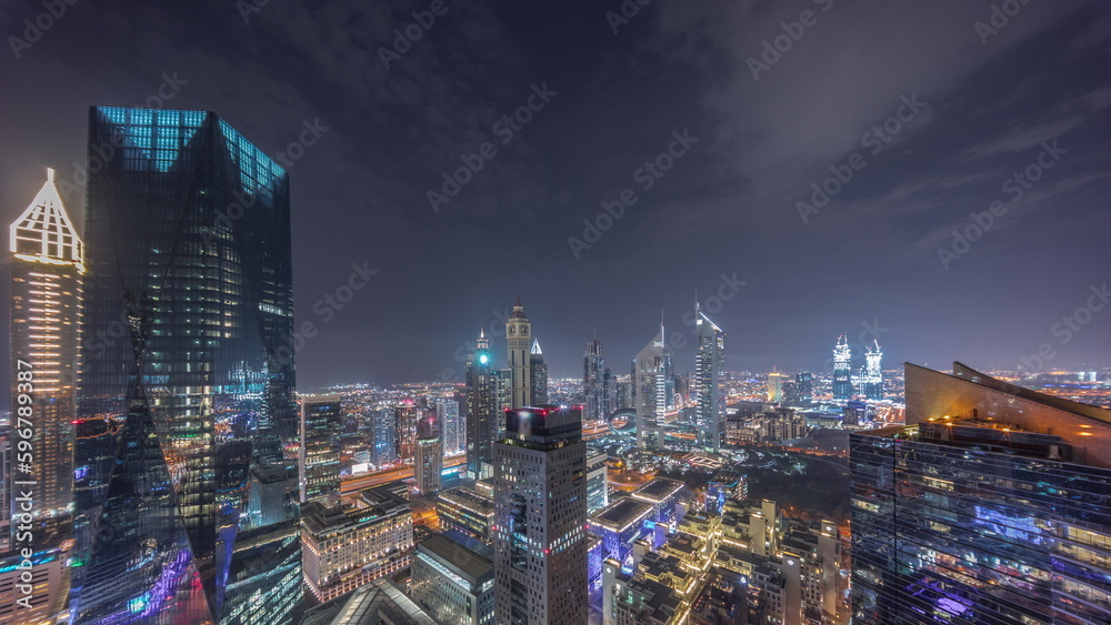 Fototapeta premium Panorama of futuristic skyscrapers in financial district business center in Dubai night timelapse