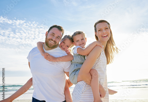 Happy family at the beach. Portrait of smiling young parents with children having fun on vacation. Little boy and girl enjoying summer with mother and father