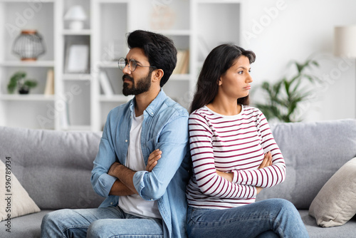 Upset young indian couple sitting on couch at home Fototapet