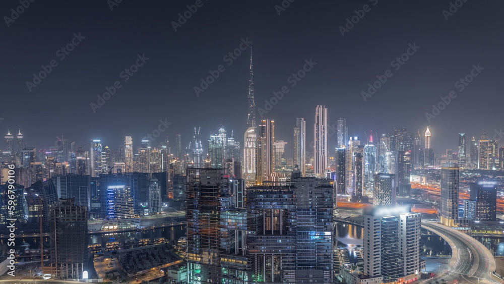Fototapeta premium Panoramic skyline of Dubai with business bay and downtown district night timelapse.