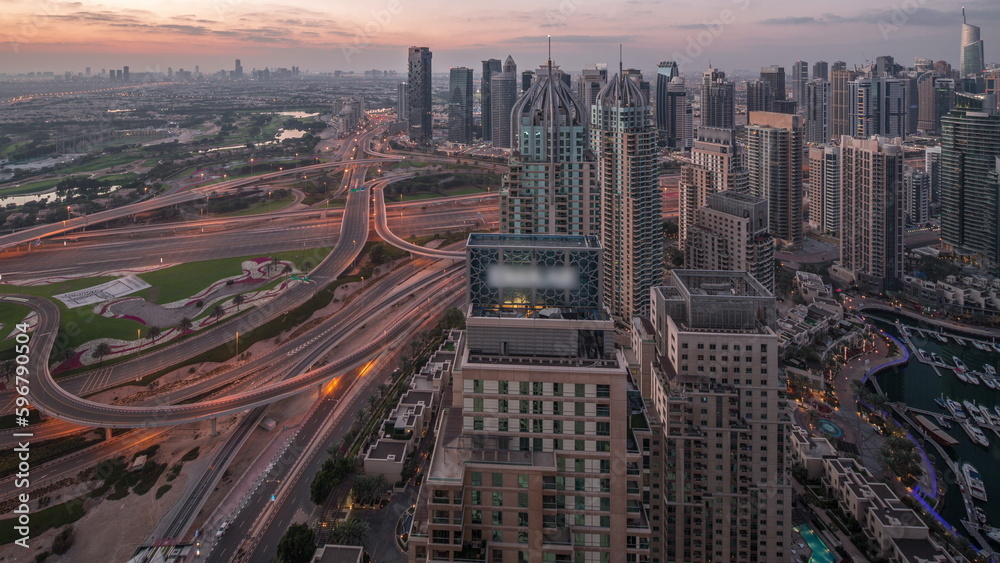 Dubai marina and JLT skyscrapers along Sheikh Zayed Road aerial night to day timelapse.