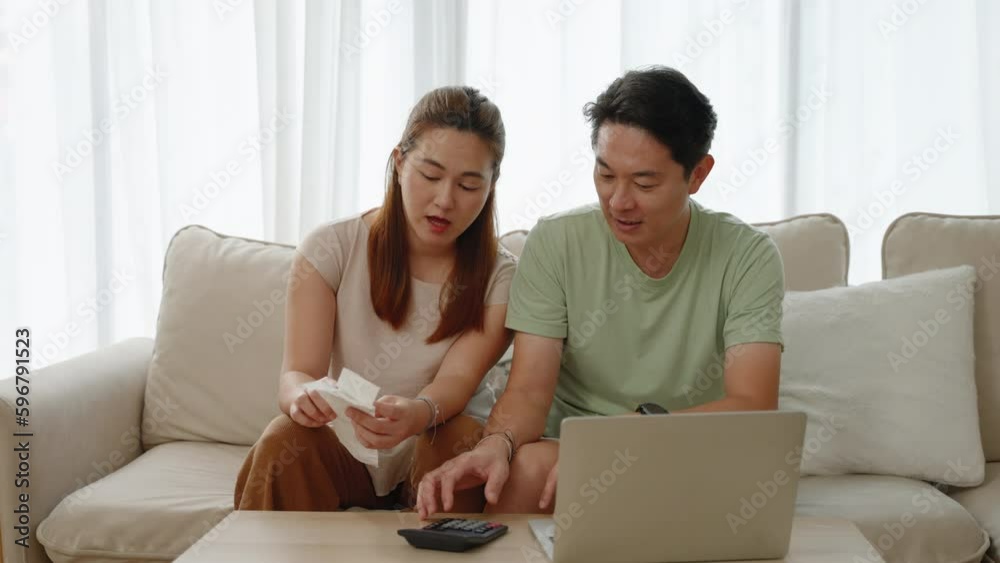 Asian couple doing family bills in the living room of the house
