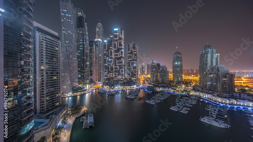 Dubai marina tallest skyscrapers and yachts in harbor aerial all night timelapse. © neiezhmakov