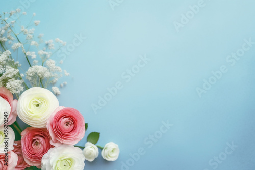 A blue background topped with beautiful flowers such as baby's breath, rose, cherry blossom and ranunculus. for banners, cards, mockups, backgrounds and template ai-generated