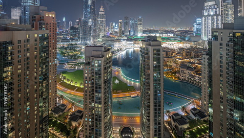 Panorama showing Dubai Downtown cityscape with tallest skyscrapers around aerial night timelapse.