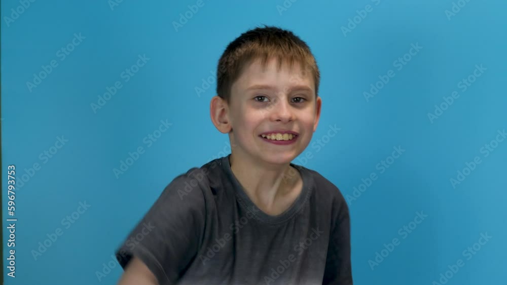 cheerful caucasian boy 10 years old looks at the camera and shows a gesture of ok. blue background, studio shooting. gesture of approval and acceptance, everything is ok cheerful caucasian boy 10 years old looks at the camera and shows a gesture of ok. blue background, studio shooting. gesture of approval and acceptance, everything is ok