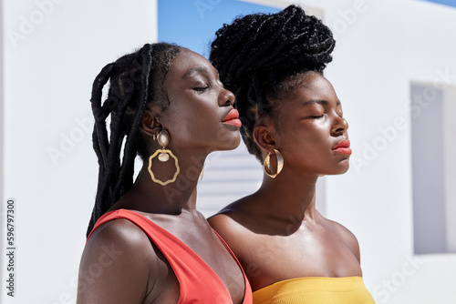 Whats a summer without colour. Cropped shot of two attractive young women posing on a rooftop outdoors. © Nicholas F/peopleimages.com