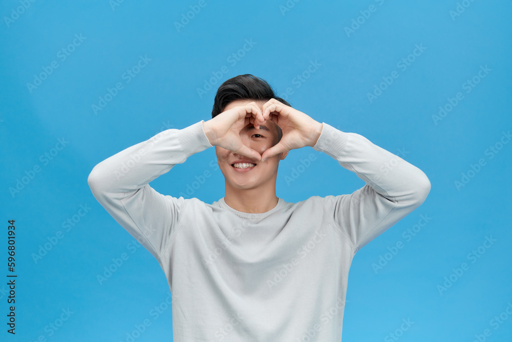Portrait of happy Asian man making heart with fingers isolated on white background Portrait of happy Asian man making heart with fingers isolated on white background