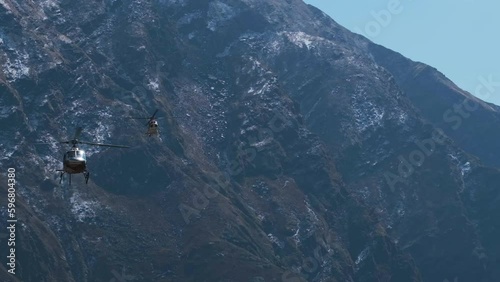 Cinematic shot of Helicopters flying over the snowy mountain of Kedarnath Peak, Uttarakhand, India. photo
