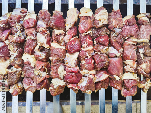 Appetizing shashlik skewers with raw lamb on grill, top view © diamant24