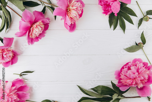 Pink and white peonies on a white wooden background  copy space  flat lay  greeting card.