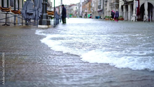 Strong streams of flood water cover small city streets