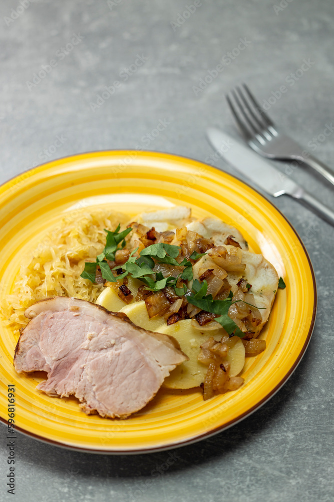 pork meat with potato dumplings and pickled cabbage served with roasted onion