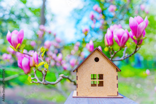 Wooden Toy House Set against Vivid Pink Magnolia Backdrop