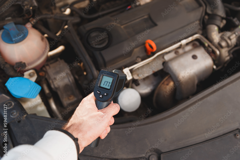 Measuring temperature of internal combustion Engine turbine by laser  infrared thermometer Stock Photo
