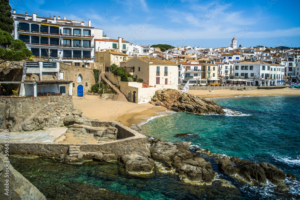 Fototapeta premium A classic white town on the Costa Brava. White houses, historical buildings of Calella de Palafrugell. Rocks, beach and sea view