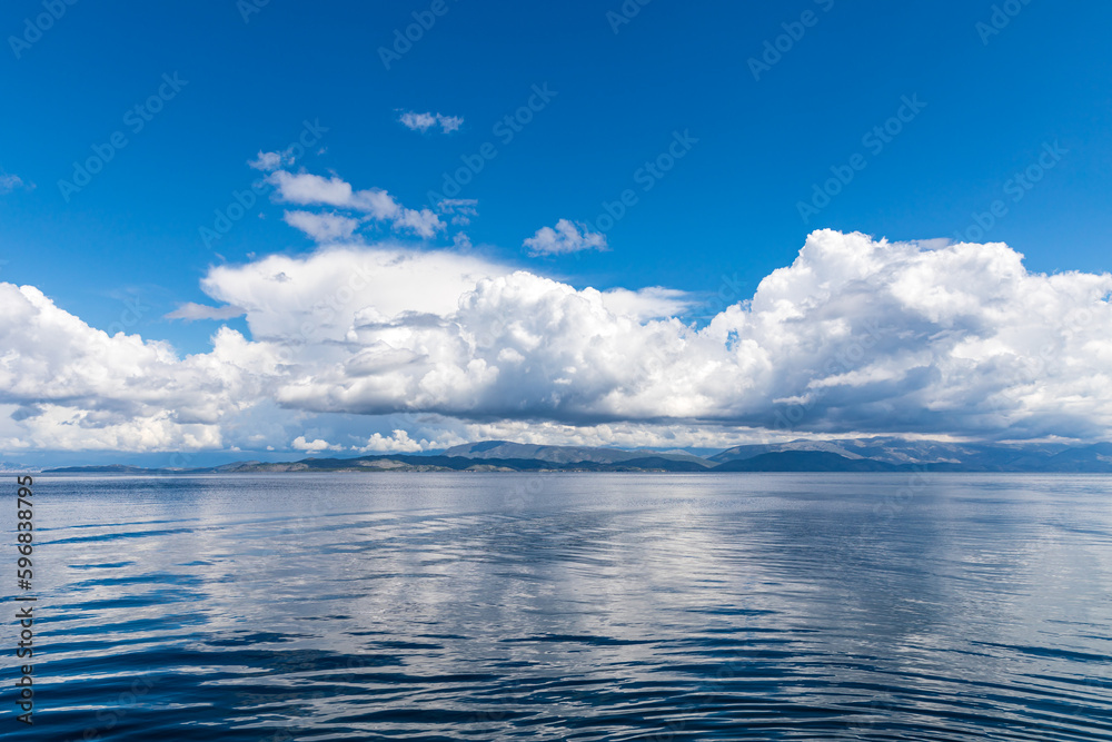 Obraz premium A beautiful landscape of the coast of the island of Corfu in the Ionian Sea of the Mediterranean in Greece. Pure blue clear water washes over the shores of the Greek island.