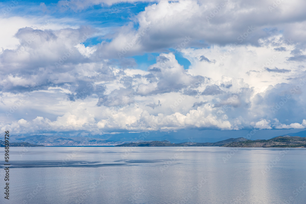 A beautiful landscape of the coast of the island of Corfu in the Ionian Sea of the Mediterranean in Greece. Pure blue clear water washes over the shores of the Greek island.