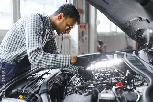 service, repair and profession concept - indian mechanic at car service