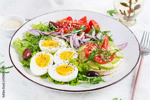 Fresh  salad with tomato, olives, boiled eggs and and sandwich with  ricotta cheese, avocado.