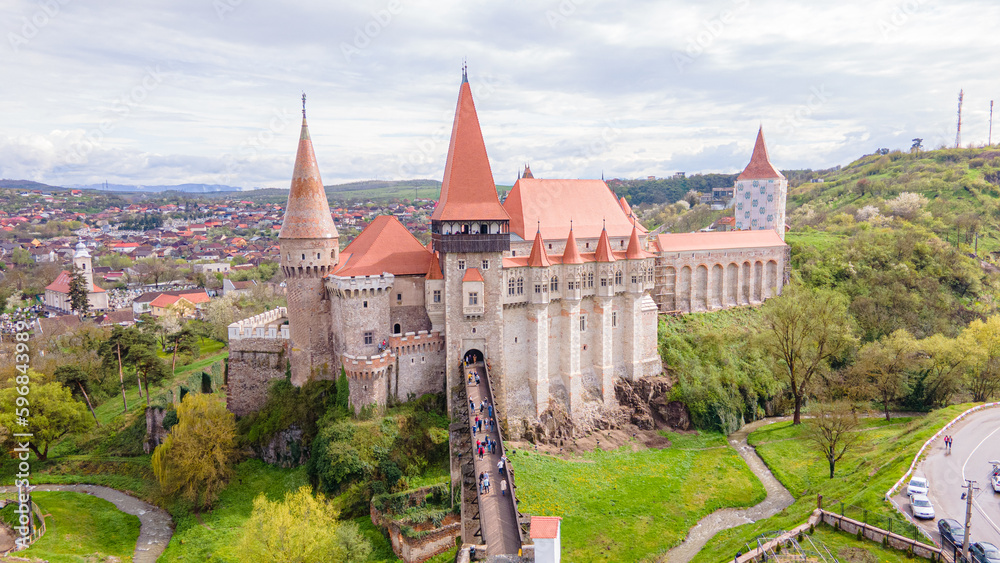 Obraz premium Aerial view of the Huniyad castle in Hunedoara, Romania in spring season, on a rainy day. Photography was shot from a drone at a lower altitude with the castle in the view.