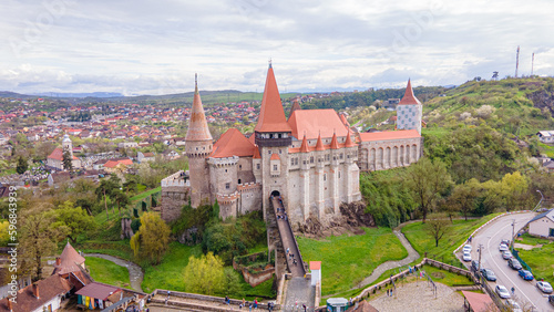 Aerial view of the Huniyad castle in Hunedoara, Romania in spring season, on a rainy day. Photography was shot from a drone at a lower altitude with the castle in the view.  photo