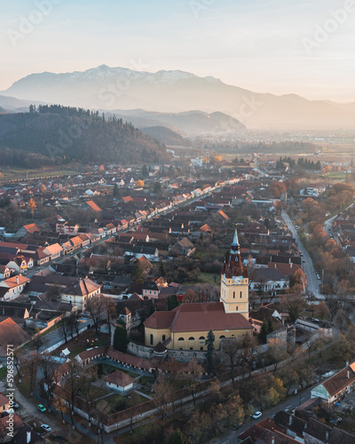Aerial view of Cristian in Transylvania at golden hour with the Bucegi mountains in the background 