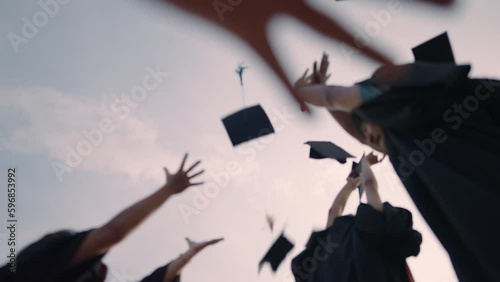 Close-up of graduation ceremony university high school graduates throwing cap on the blue sky.